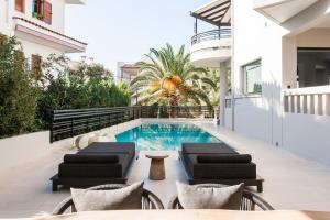 雅典Sol Residence - Private Pool Gym Glyfada的一座带游泳池和两把躺椅的房子