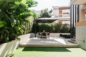 雅典Sol Residence - Private Pool Gym Glyfada的庭院里设有带桌子和遮阳伞的庭院。