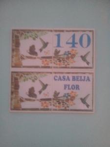 圣托梅-达斯莱特拉斯Casa Beija Flor的墙上的标志,上面有时钟