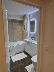 滨海利leigh Penthouse Apartment的带浴缸、盥洗盆和卫生间的浴室