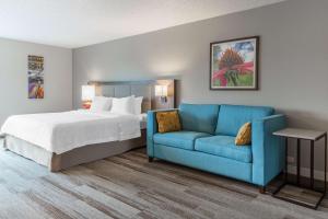 奥那拉斯加拉克罗斯/奥纳拉斯卡汉普顿酒店的一间卧室配有一张床和一张蓝色的沙发