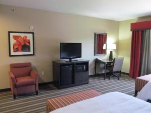霍普霍普汉普顿套房酒店的酒店客房设有电视、椅子和书桌