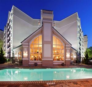 达拉姆希尔顿惠庭套房酒店 -罗利 - 达勒姆机场的建筑前的一座带游泳池的建筑