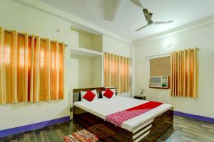 巴特那OYO Flagship Hotel Shubhmangalam的一间卧室配有红色枕头的床