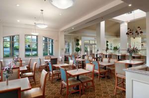 兰乔米拉日棕榈泉/牧场米拉吉希尔顿花园旅馆的餐厅设有桌椅和窗户。
