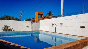 阿雷贝贝Pousada Paraiso de Arempebe的白色墙壁前的游泳池