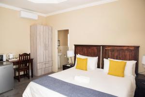 波罗瓜尼M n M Guesthouse Polokwane Central的一间卧室配有一张带黄色枕头的大床
