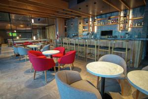 圣卡洛斯-德巴里洛切Hampton By Hilton Bariloche的一间带桌椅的餐厅和一间酒吧