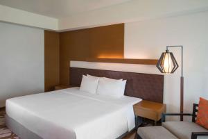 宿务Radisson Blu Cebu的卧室配有一张白色大床和一把椅子