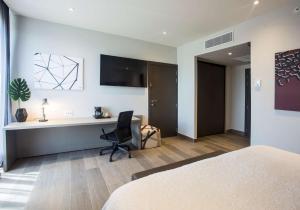 戴维Hampton by Hilton David, Panamá的一间卧室配有书桌、一张床和一把椅子