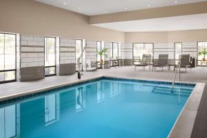 夏洛特Hampton Inn & Suites Charlotte Steele Creek Road, NC的游泳池位于酒店客房内,配有桌椅