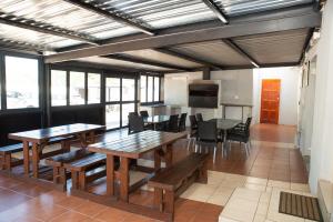 波罗瓜尼M n M Guesthouse Polokwane Central的用餐室配有木桌和椅子