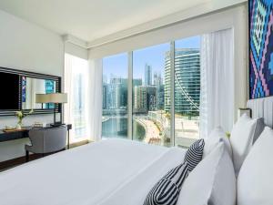 迪拜Pullman Dubai Downtown的一间卧室设有一张大床和一个大窗户