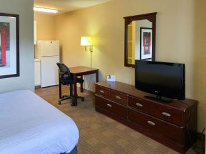 哥伦布Studio 6 Columbus GA Columbus Airport的酒店客房配有一张床、一台电视和一张书桌。