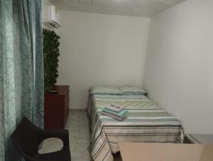 卡利El Hogar de Ami的小房间设有一张床和一把椅子