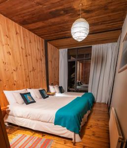 皮奇勒姆Surf Lodge Punta de Lobos的一间卧室配有一张带木墙的大床