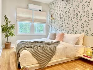 西雅图Cabin Vibes Condo in North Capitol Hill的卧室配有白色床和花卉壁纸