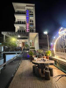 头顿Sao Mai Hotel & Apartment的阳台配有桌子,晚上则设有建筑