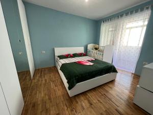 KukësKukes Apartment Hotel的一间卧室配有一张带绿色棉被的床