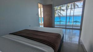 帕洛米诺Beach Life Palomino - Beach Club & Party Hostel的一间卧室设有一张床,享有海景