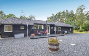埃贝尔托夫特Awesome Home In Ebeltoft With Sauna的一座黑色的小房子,设有庭院和一张桌子