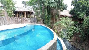 外南梦The Osing Bamboo Resort - a LIBERTA Collection的一个带凉亭的庭院内的游泳池