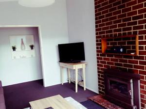 CorryongWild Brumby- A cozy home away from home的客厅设有壁炉和电视。