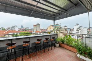 河内Golden Sun Hotel的阳台设有酒吧凳,享有城市美景。