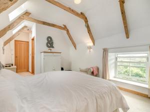 Saint Just in RoselandMyrtle Cottage的卧室配有白色的床和窗户。
