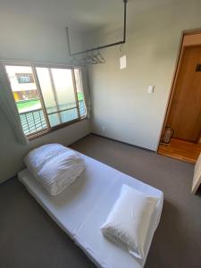 洞爷湖The Toya的卧室配有白色的床和两个枕头