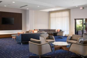 拉伯克拉伯克市中心万怡酒店的带沙发和椅子的等候室和投影屏幕