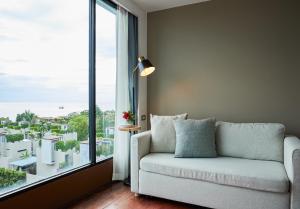 华欣华欣罗丽哥度假酒店的带沙发和大窗户的客厅