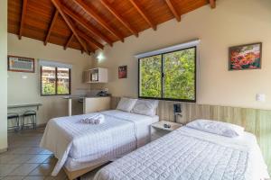 弗洛里亚诺波利斯Jurerê Ocean Flats的一间带两张床的卧室和一间厨房