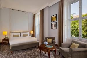 维也纳丽思卡尔顿酒店维也纳酒店的一间卧室配有一张床、一张沙发和一把椅子
