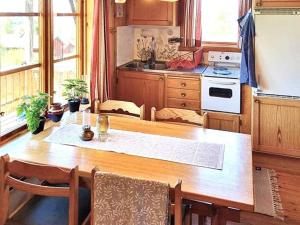 赖特维克Holiday home RÄTTVIK的一间带木桌的厨房和一间带炉灶的厨房