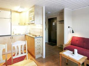 斯托滕Holiday home SÄLEN的一间带红色沙发的客厅和一间厨房