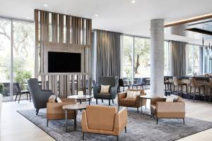 凤凰城AC Hotel Phoenix Biltmore的大堂设有桌椅和平面电视。