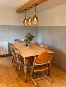 弗罗姆Cottage in the Heart of Frome的一张带椅子的木桌和花瓶