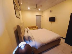 伊斯兰堡Travel Inn islamabad的一间小卧室,配有一张床和电视