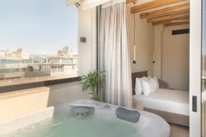 雅典Living Stone Condo Hotel的带浴缸的酒店客房和一间卧室