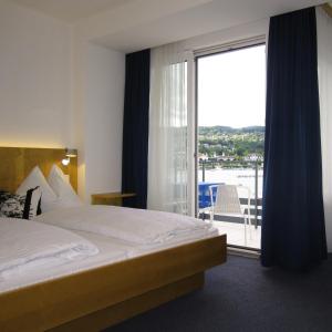 沃尔特湖畔韦尔登Hotel Garni Ogris Am See的酒店客房,设有床和滑动玻璃门
