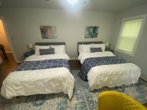 亚特兰大East Point Atlanta - Spacious 5BR Retreat!的一间卧室配有两张床和一张黄色椅子