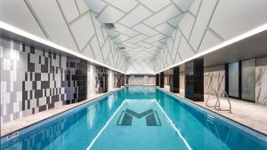 利物浦Meriton Suites Liverpool的一座带瓷砖天花板的大型游泳池