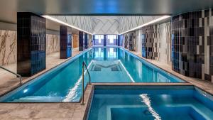 利物浦Meriton Suites Liverpool的大楼内的一个蓝色海水游泳池