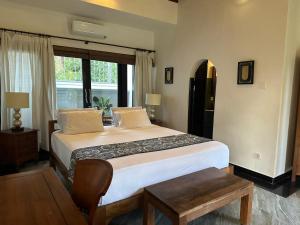 坎古普里香鱼酒店的一间卧室设有一张大床和一个窗户。