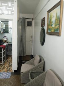 蒙巴萨Paradise Apartment的客厅配有两把椅子和墙上的照片