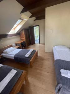 马里扬泊列Akmenine Kerpe的客房设有两张床,铺有木地板。