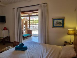 塔马兰香提小屋旅馆的一间卧室配有一张带蓝色毛巾的床