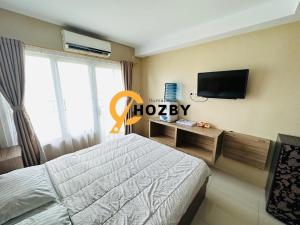 SunggalSkyview Premier Suites Hozby的一间卧室配有一张床和一台平面电视