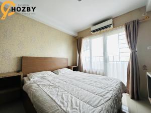 SunggalSkyview Premier Suites Hozby的一间卧室设有一张大床和一个窗户。